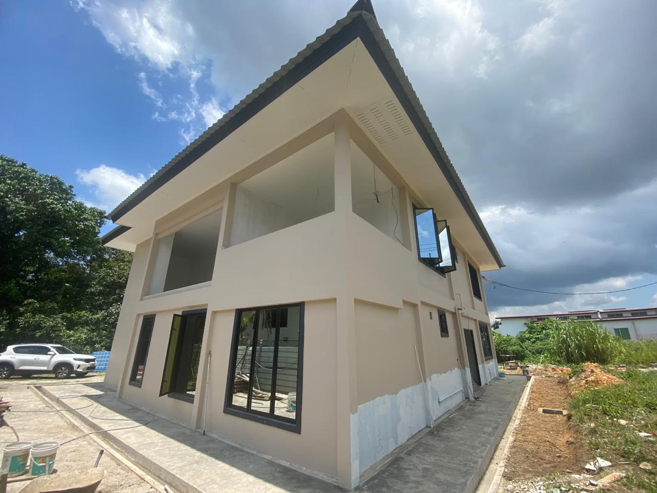 Painted two-storey house with black window frames and an open upper balcony