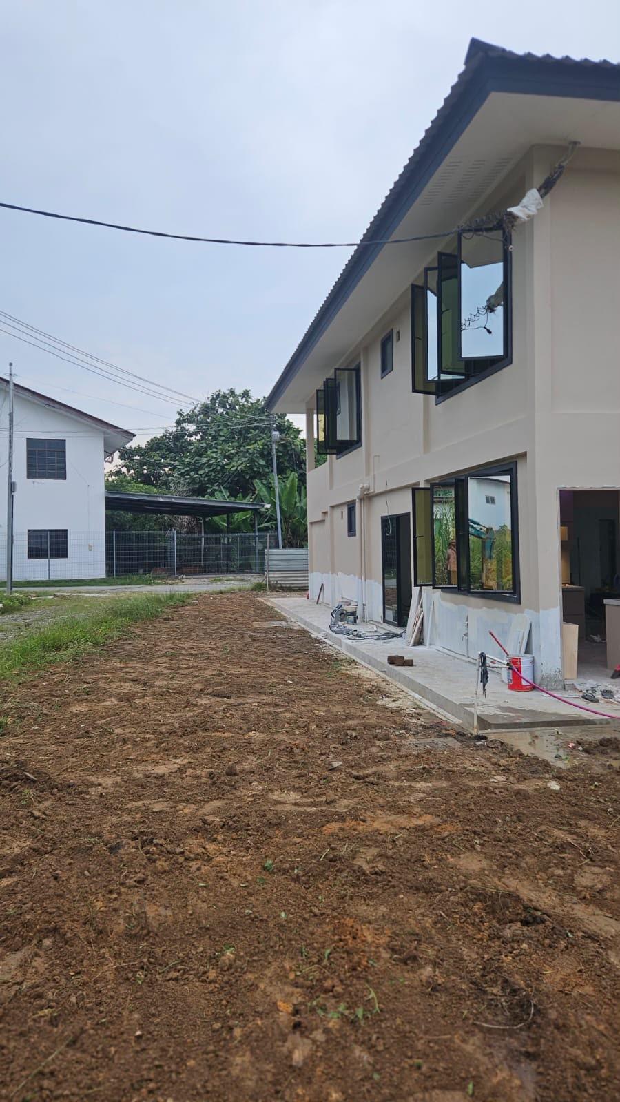 Side of the house with folding windows open and the ground prepared in front